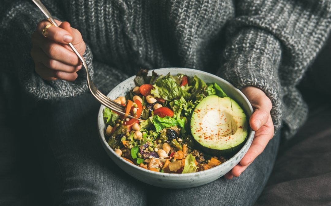 Woman eating healthy vegetarian dinner from Buddha bowl, close-up