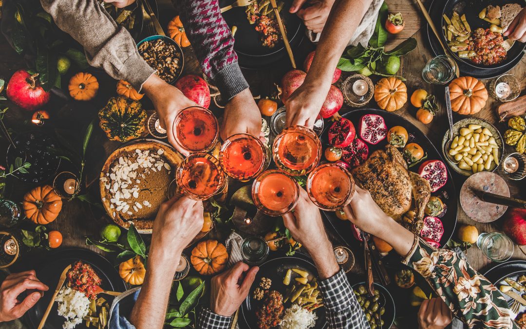 Family celebrating Thanksgiving day with Autumn food and rose wine